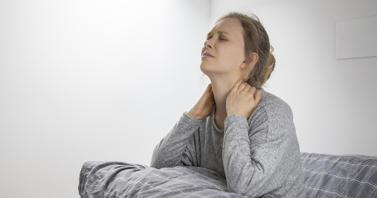 Tired sick woman on bed touching her neck, suffering from pain in lucid dreaming